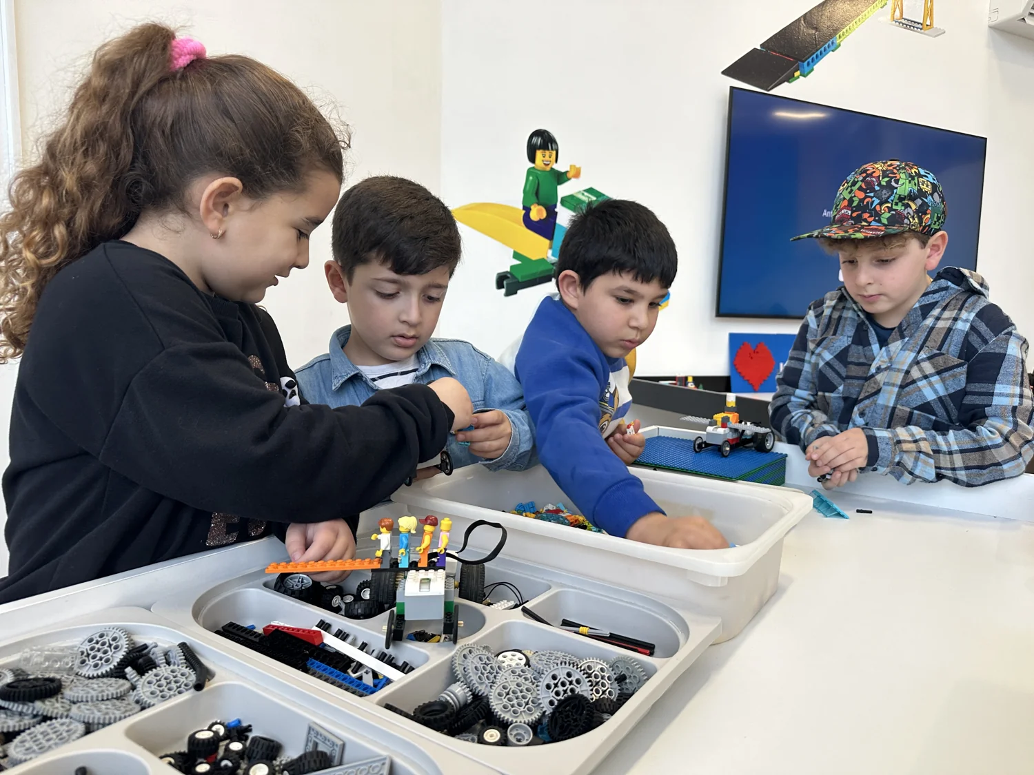Children choosing building pieces and working on models together