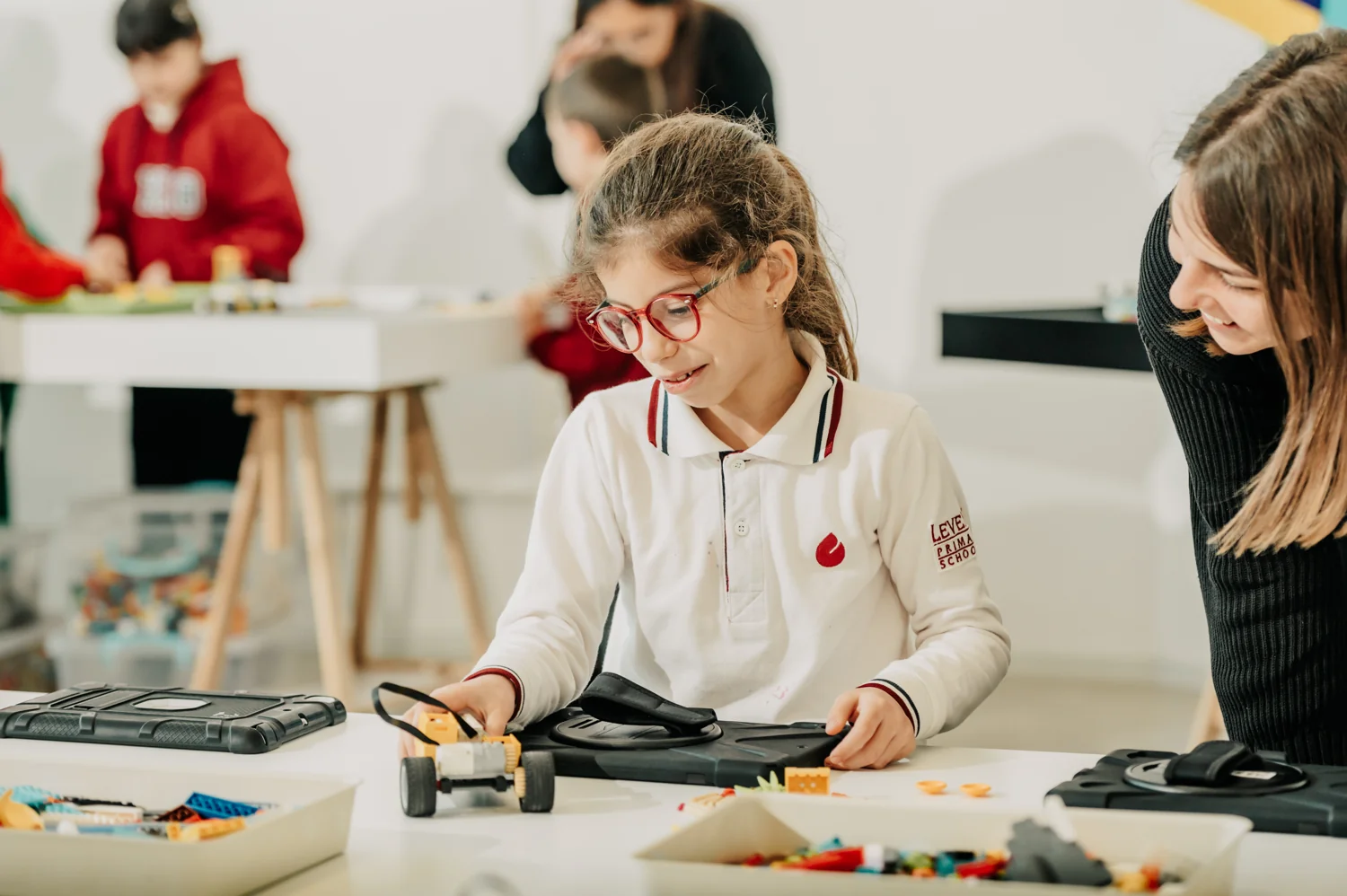 A child testing a robot with support from an adult