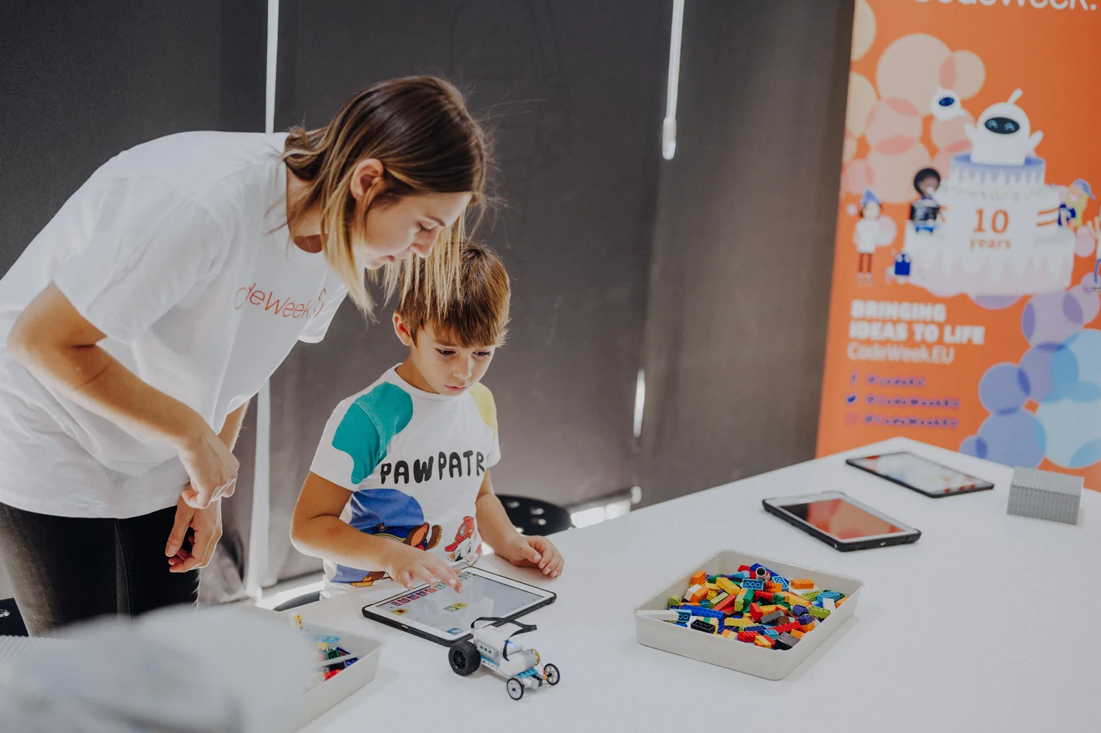 An educator helping a child with coding