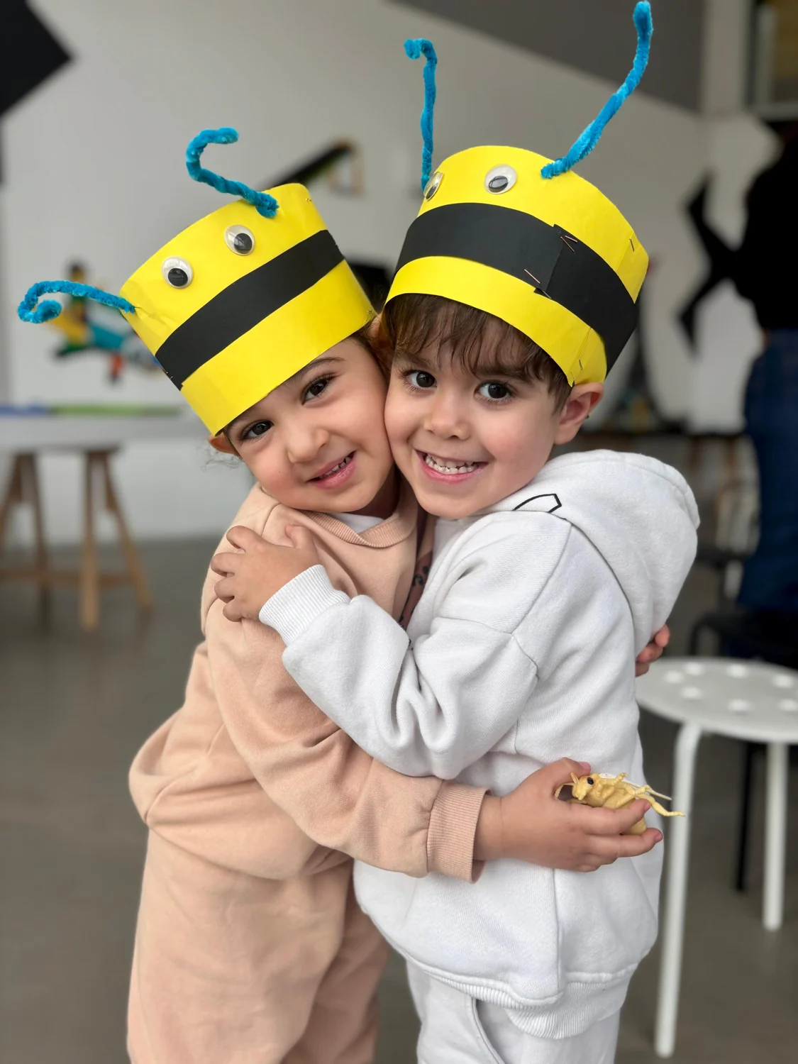Two children wearing handmade bee hats