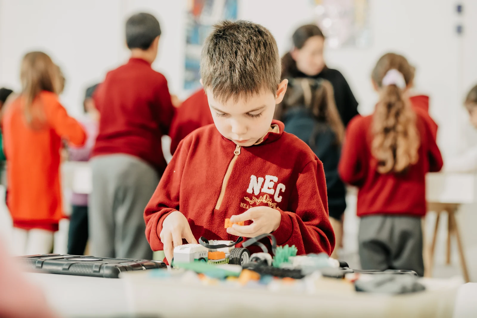 A child building with LEGO® bricks and classroom materials