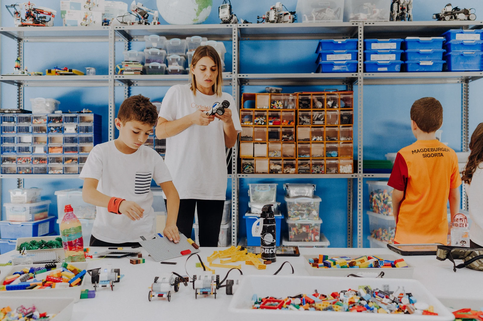 Children exploring models and construction materials with a teacher