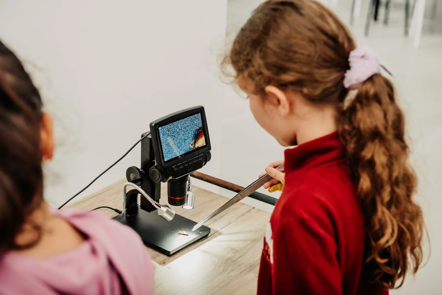 A child examining a specimen with a digital microscope