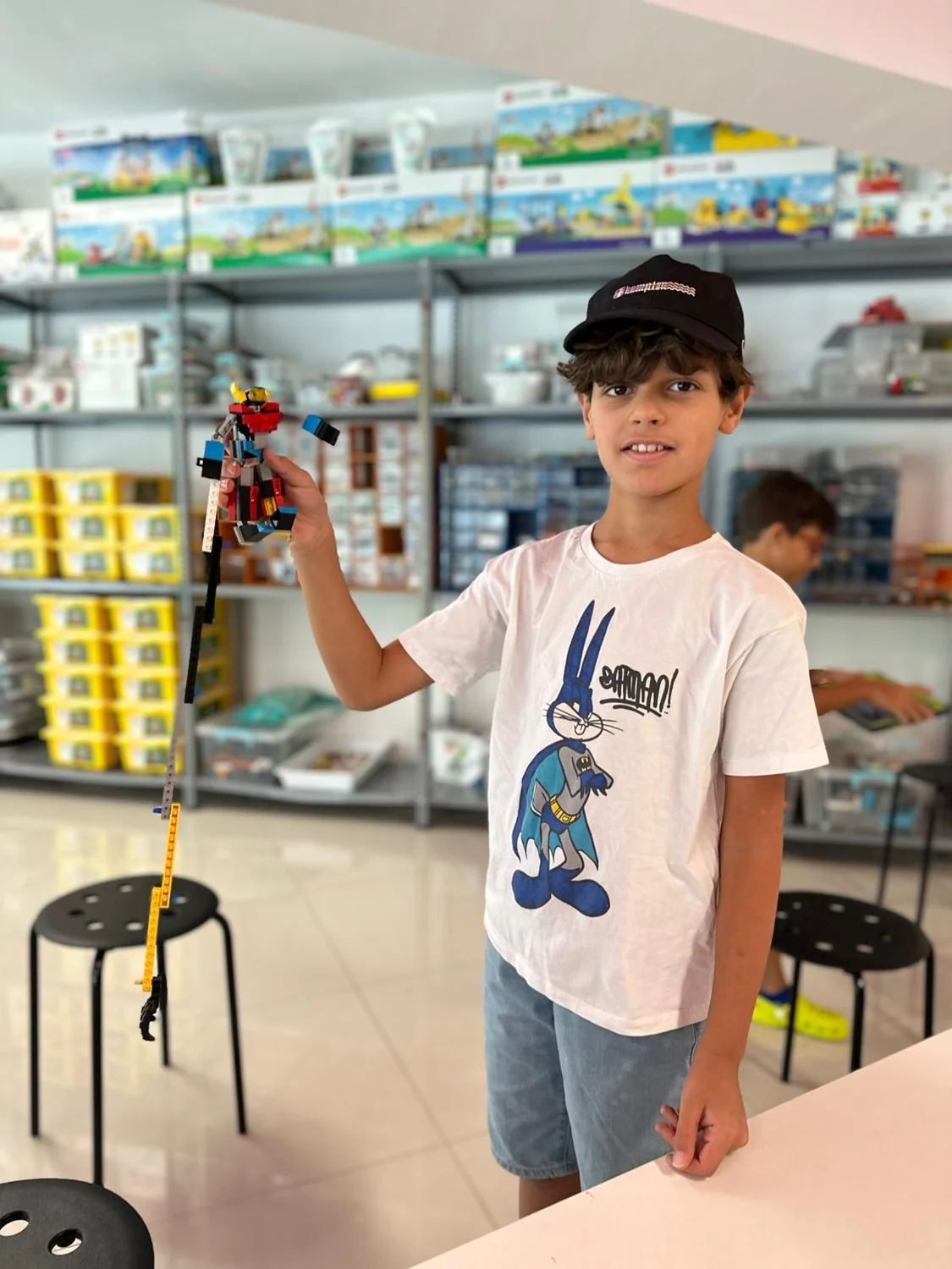 A child presenting a model built with construction pieces